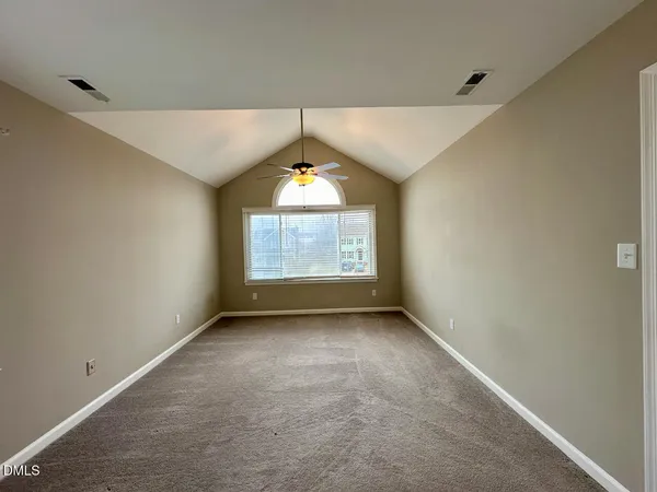 an empty room with a window and a fan