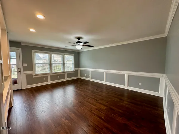 a view of an empty room with a window and wooden floor