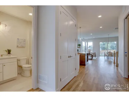 a open hall with white cabinets and wooden floor