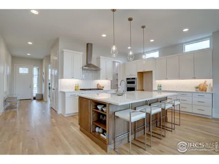 a kitchen with stainless steel appliances kitchen island granite countertop a table chairs sink and cabinets