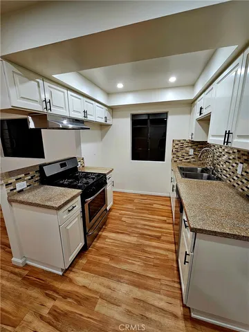 a kitchen with stainless steel appliances granite countertop a stove and a sink