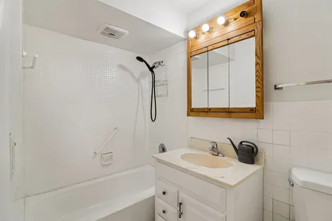 a bathroom with a granite countertop sink toilet and shower