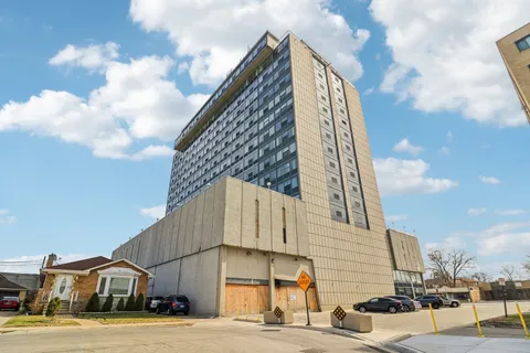 a view of a tall building next to a yard