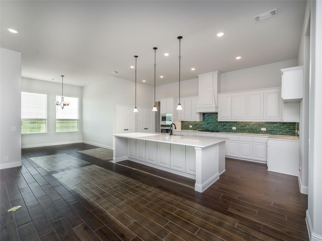 2108 Charters Circle Nevada, TX 75173 - Photo 13 of 37 Kitchen featuring white cabinetry, an island with sink, backsplash, recessed lighting, and decorative light fixtures