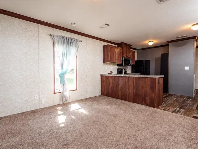 a kitchen with a refrigerator a sink dishwasher with a stove top oven a refrigerator with wooden cabinets and floor