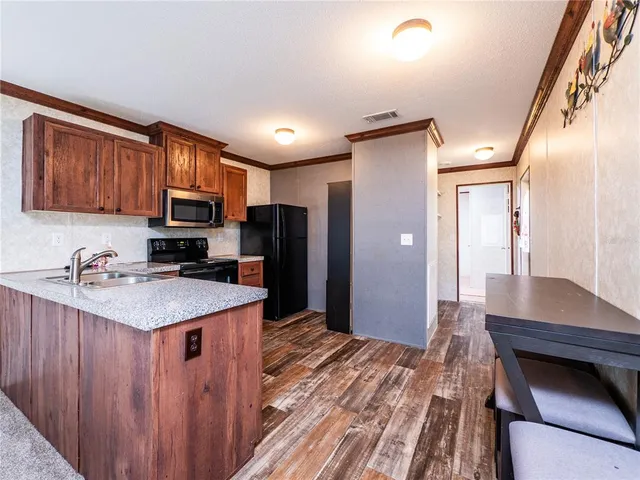 a kitchen with stainless steel appliances granite countertop a refrigerator and a stove top oven