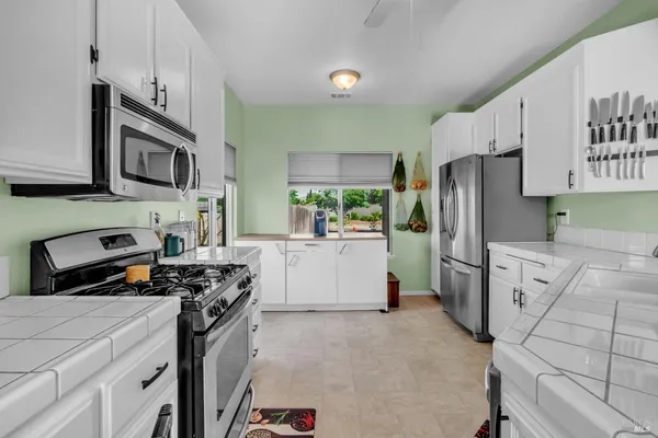 a kitchen with stainless steel appliances a refrigerator sink and stove top oven