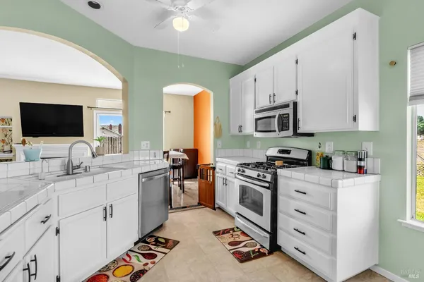 a kitchen with granite countertop a sink a stove and cabinets