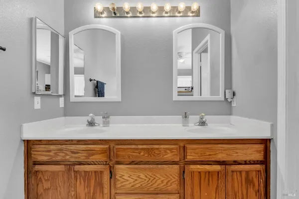 a bathroom with a granite countertop sink a mirror and cabinets