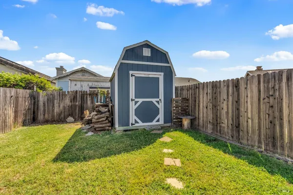 a view of a small yard in front of a house with wooden fence