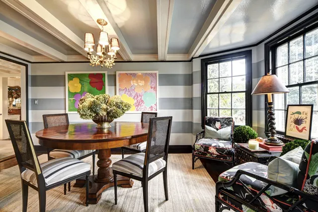 a dining room with stainless steel appliances granite countertop a table chairs and a refrigerator