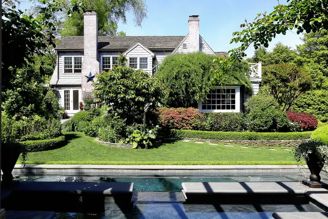 a view of a swimming pool with lawn chairs and a big yard