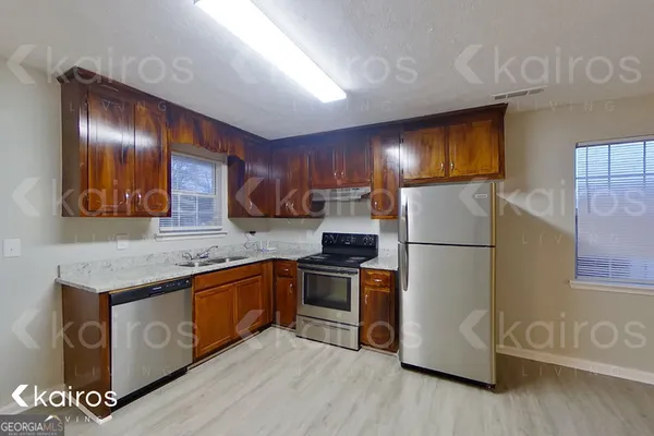 a kitchen with stainless steel appliances granite countertop a refrigerator a stove a sink and a microwave