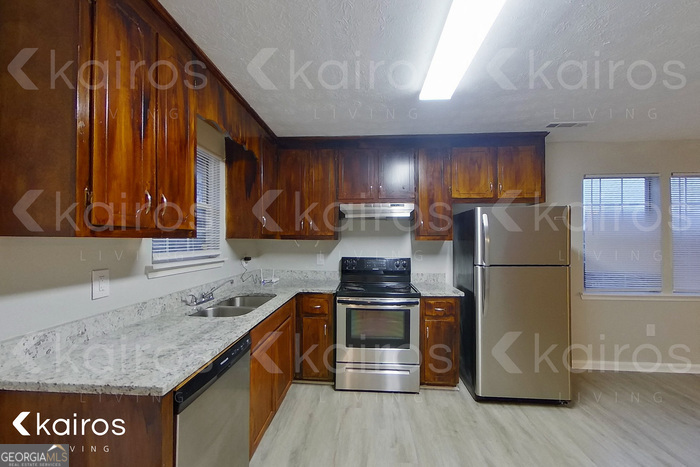 100 Deer Parkway Athens, GA 30605 - Photo 6 of 22 a kitchen with stainless steel appliances granite countertop a refrigerator a stove and a sink with wooden floors