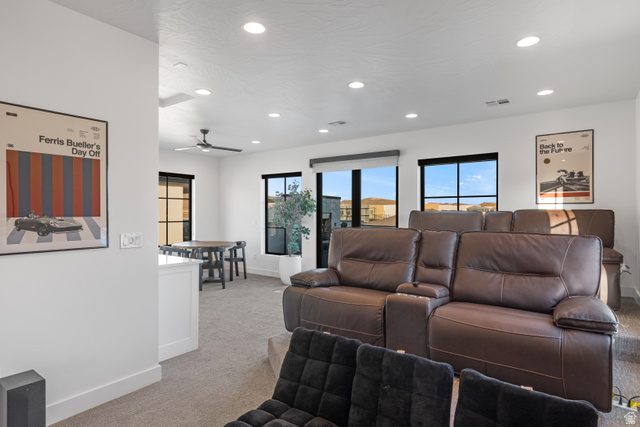 5367 Cyan Lane St. George, UT 84790 - Photo 48 of 49 Spacious entertainment room featuring tiered seating, recessed lighting, large windows with black frames, and carpeted flooring