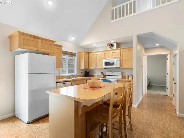 a dining hall with stainless steel appliances granite countertop a dining table and chairs