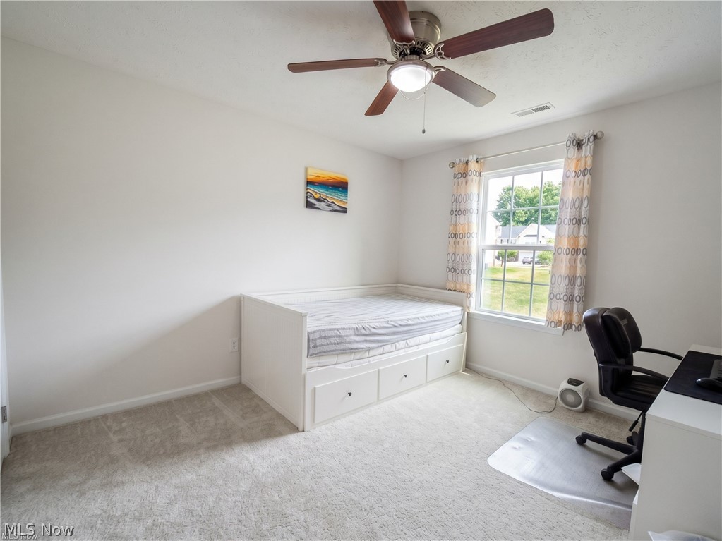 4509 Millbrook Way Akron, OH 44321 - Photo 25 of 27 Bright room featuring a ceiling fan with light fixture, light gray carpeting, and a window with white trim