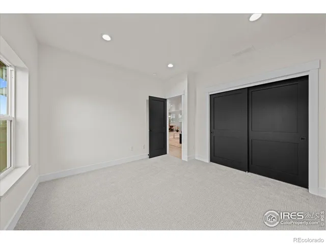 a view of an empty room with window and bathroom