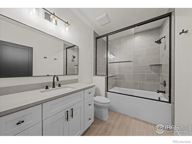 a bathroom with a shower sink vanity mirror and toilet