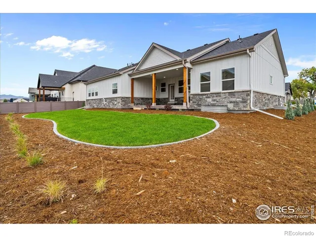 a view of a white house with a big yard and potted plants