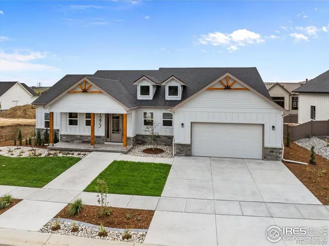 a front view of a house with a garden and plants