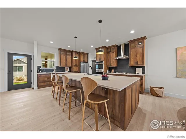 a kitchen with stainless steel appliances granite countertop a table chairs and a refrigerator