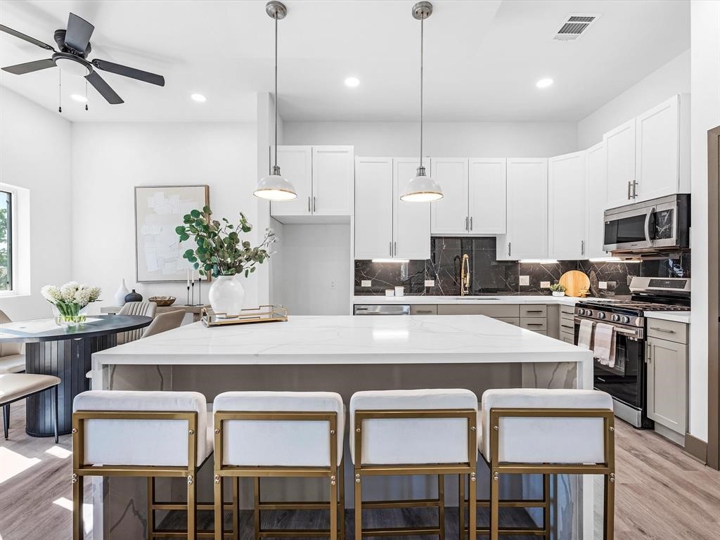 3620 Lehall Street Houston, TX 77021 - Photo 17 of 32 a kitchen with a table chairs refrigerator and microwave
