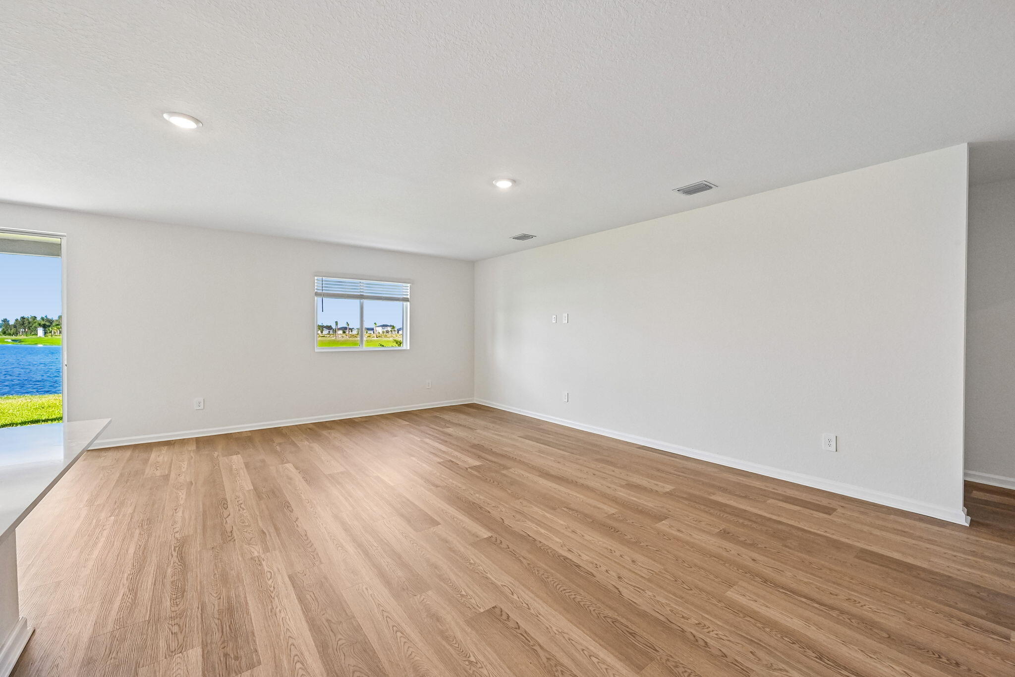 14503 Southwest New Dawn Road Indiantown, FL 34956 - Photo 6 of 42 a view of an empty room with window and wooden floor