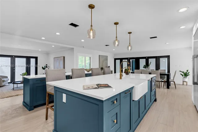 a living room with stainless steel appliances furniture a dining table and kitchen view