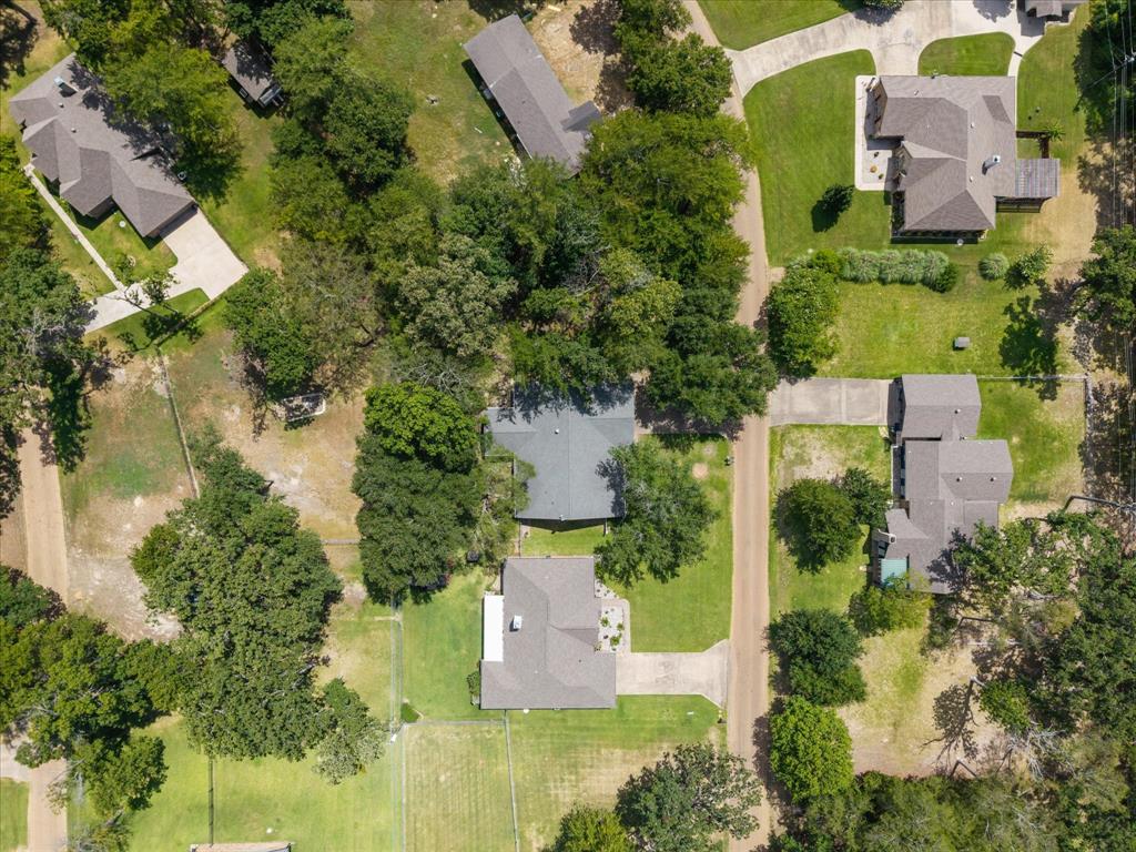 116 Meadowood Road Enchanted Oaks, TX 75156 - Photo 35 of 37 Aerial perspective showcasing multiple properties, each featuring a pitched roof, mature trees, and a concrete driveway