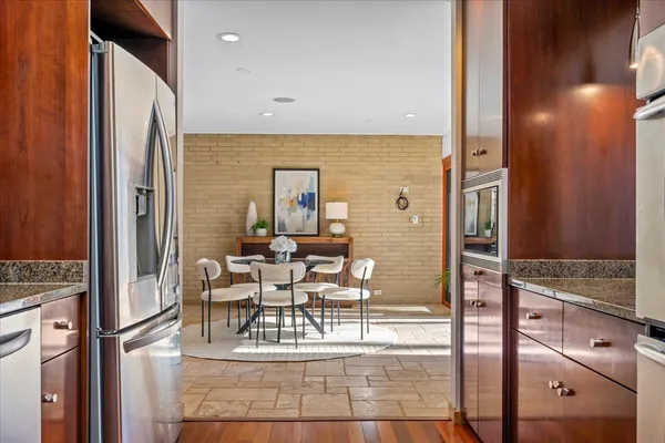 a kitchen with stainless steel appliances granite countertop a refrigerator and a stove top oven