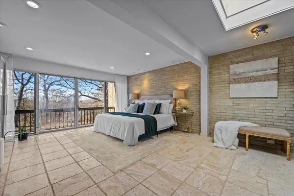 a bedroom with a bed a mirror and a window