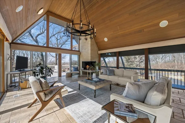 a living room with furniture a large window and a chandelier