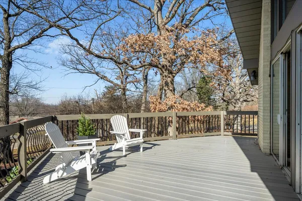 a balcony with wooden floor table and chairs
