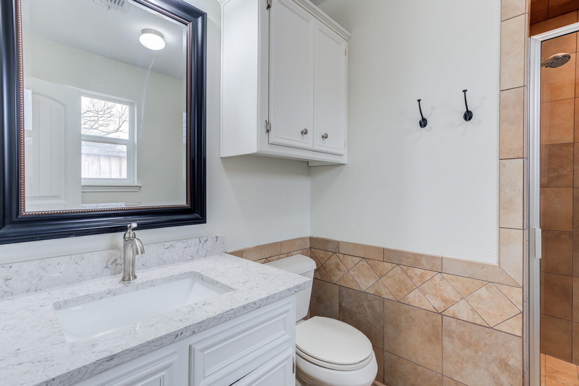 5309 77th Street Lubbock, TX 79424 - Photo 16 of 36 a bathroom with a granite countertop sink mirror vanity and toilet