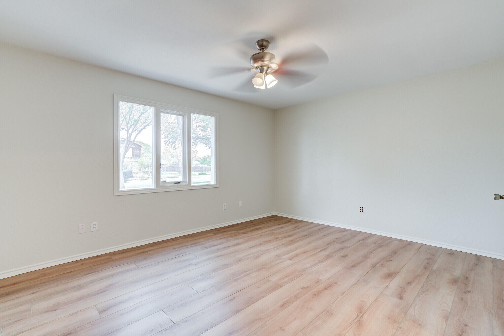 5309 77th Street Lubbock, TX 79424 - Photo 23 of 36 a view of an empty room with wooden floor and a window