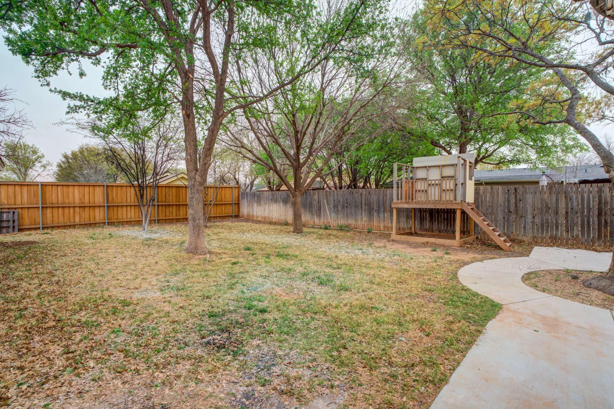 5309 77th Street Lubbock, TX 79424 - Photo 30 of 36 a backyard of a house with childrens swings and slide