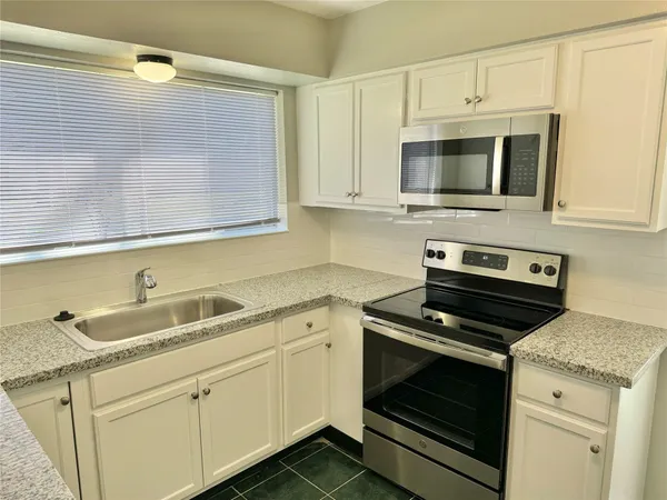 a kitchen with cabinets stainless steel appliances and a sink