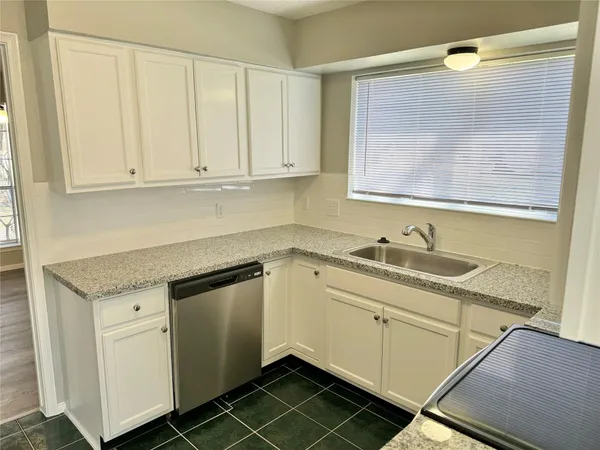 a utility room with a sink window and cabinets