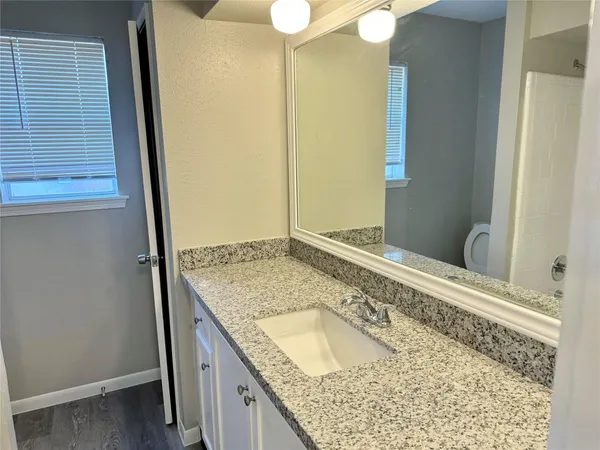 a bathroom with a granite countertop sink and a mirror