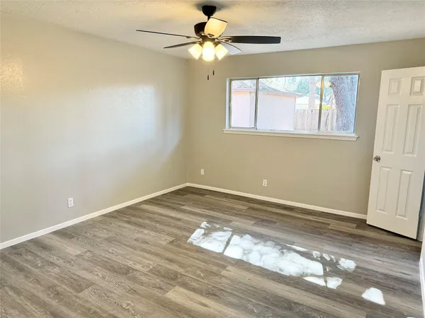 a view of a room with wooden floor and a window