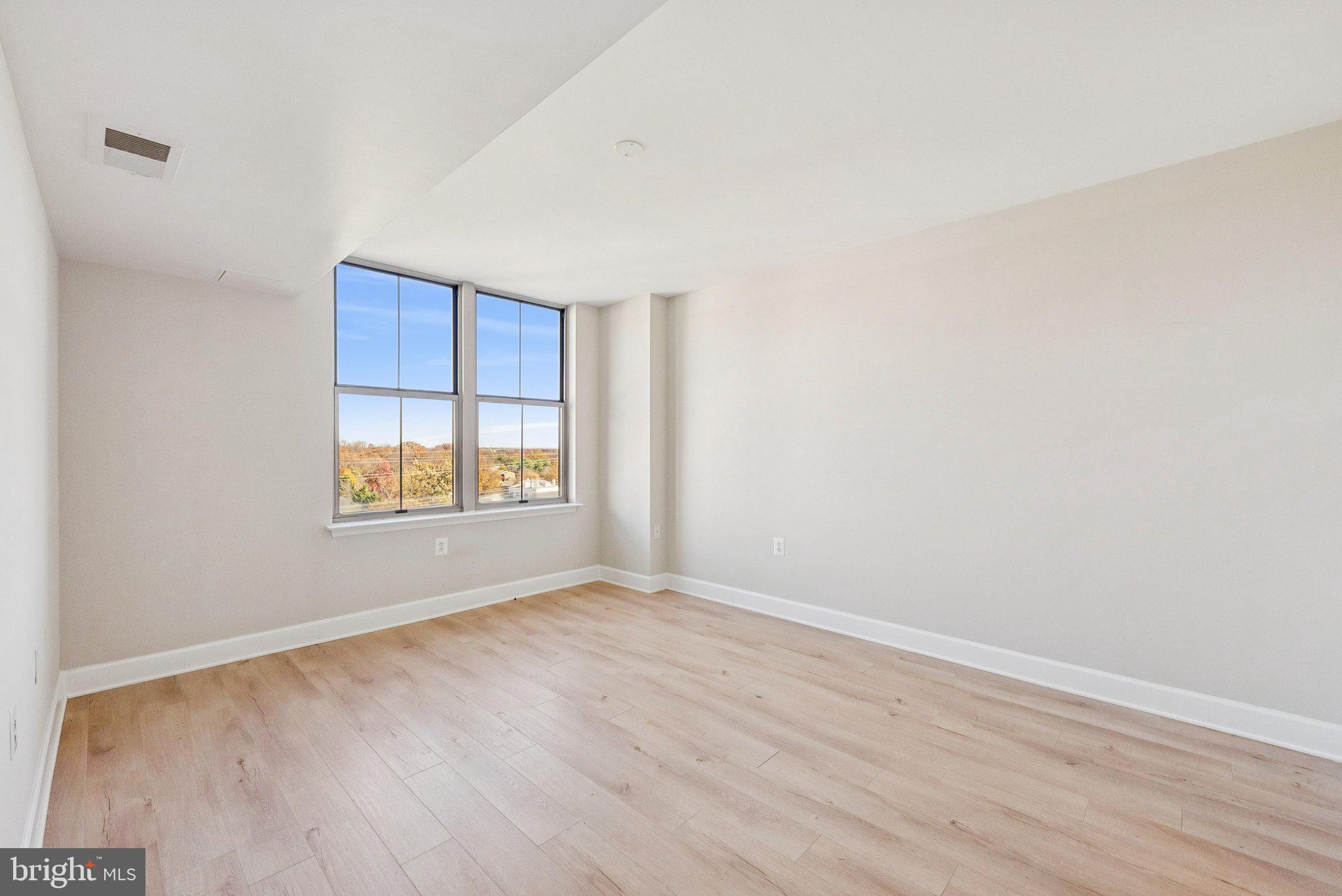 11800 Sunset Hills Road, Unit 1125 Reston, VA 20190 - Photo 14 of 24 a view of an empty room with wooden floor and a window