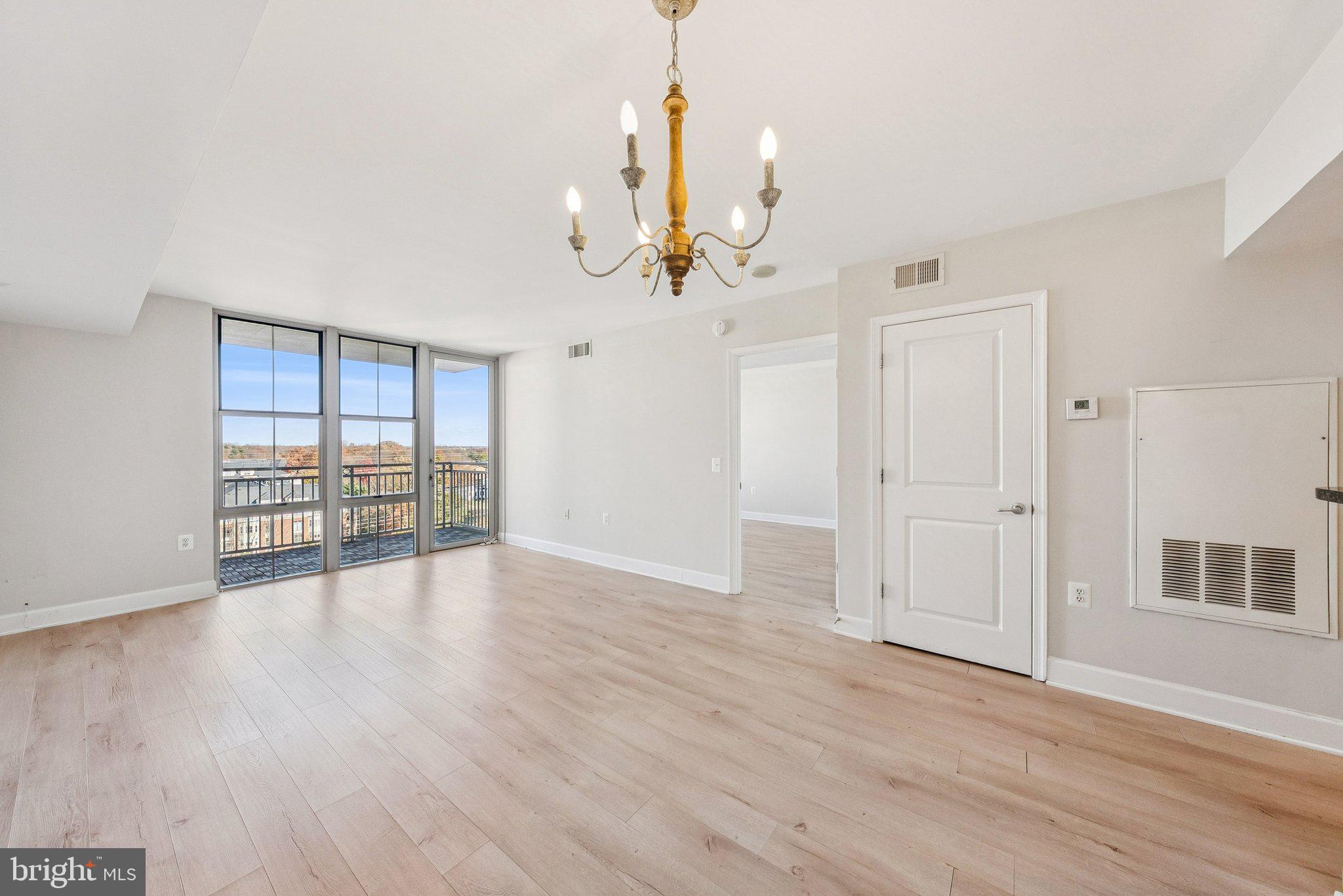 11800 Sunset Hills Road, Unit 1125 Reston, VA 20190 - Photo 4 of 24 a view of an empty room with wooden floor and a window