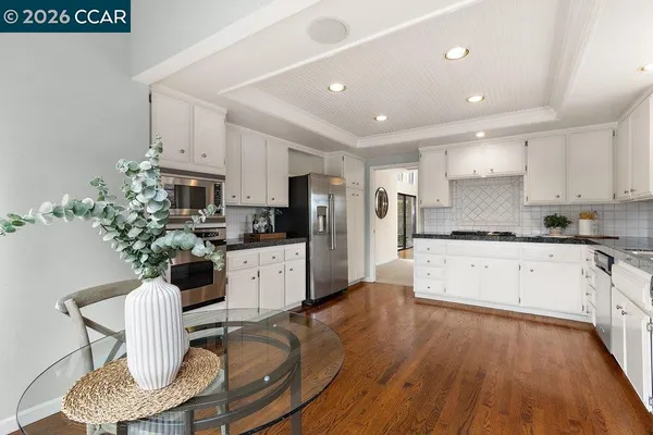 a kitchen with stainless steel appliances granite countertop a stove top oven a sink with cabinets and wooden floor