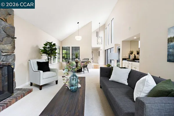 a living room with furniture a fireplace and a large window