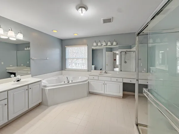 a large spacious bathroom with a large tub shower and sink