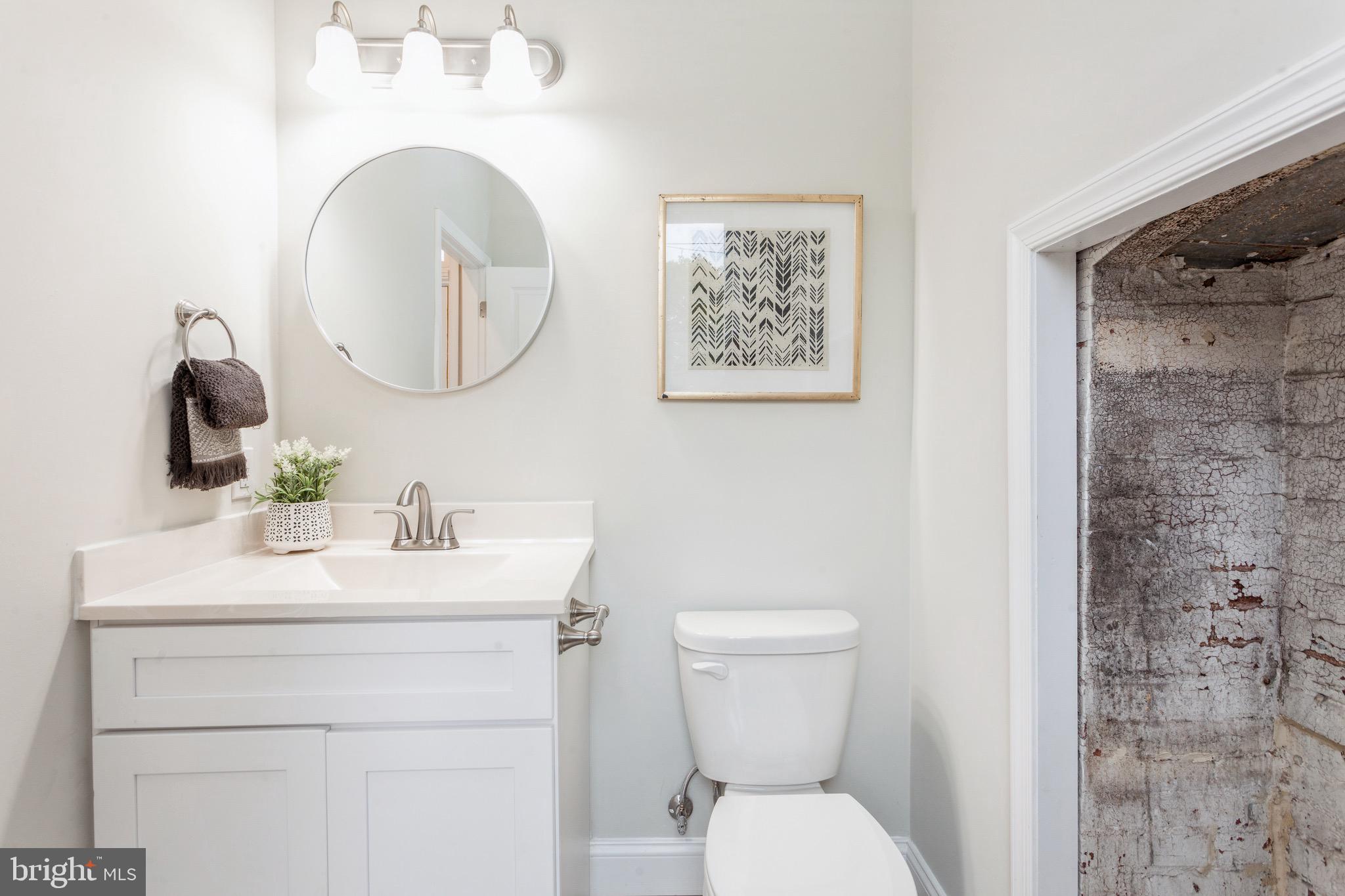 1010 North Broadway Baltimore, MD 21205 - Photo 13 of 37 a bathroom with a toilet a sink and a mirror