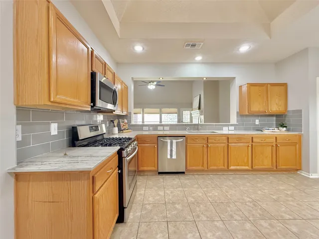 a kitchen with stainless steel appliances granite countertop a stove sink and cabinets