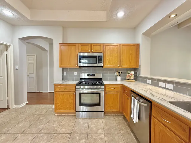 a kitchen with stainless steel appliances granite countertop a stove a sink and a microwave