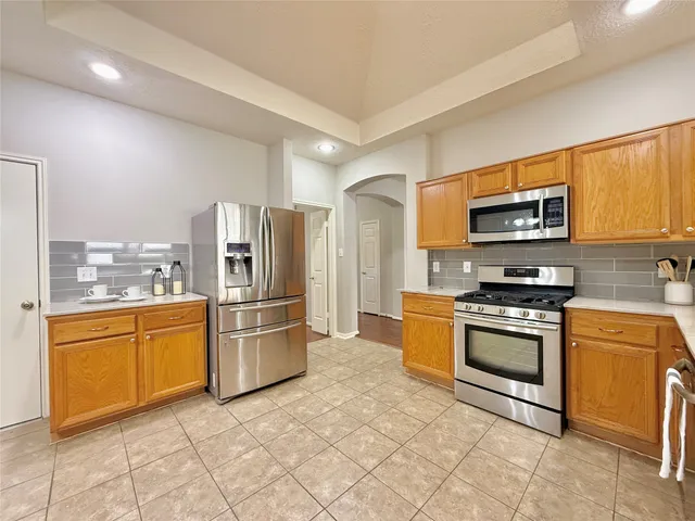 a kitchen with stainless steel appliances granite countertop a stove top oven a refrigerator and a stove top oven